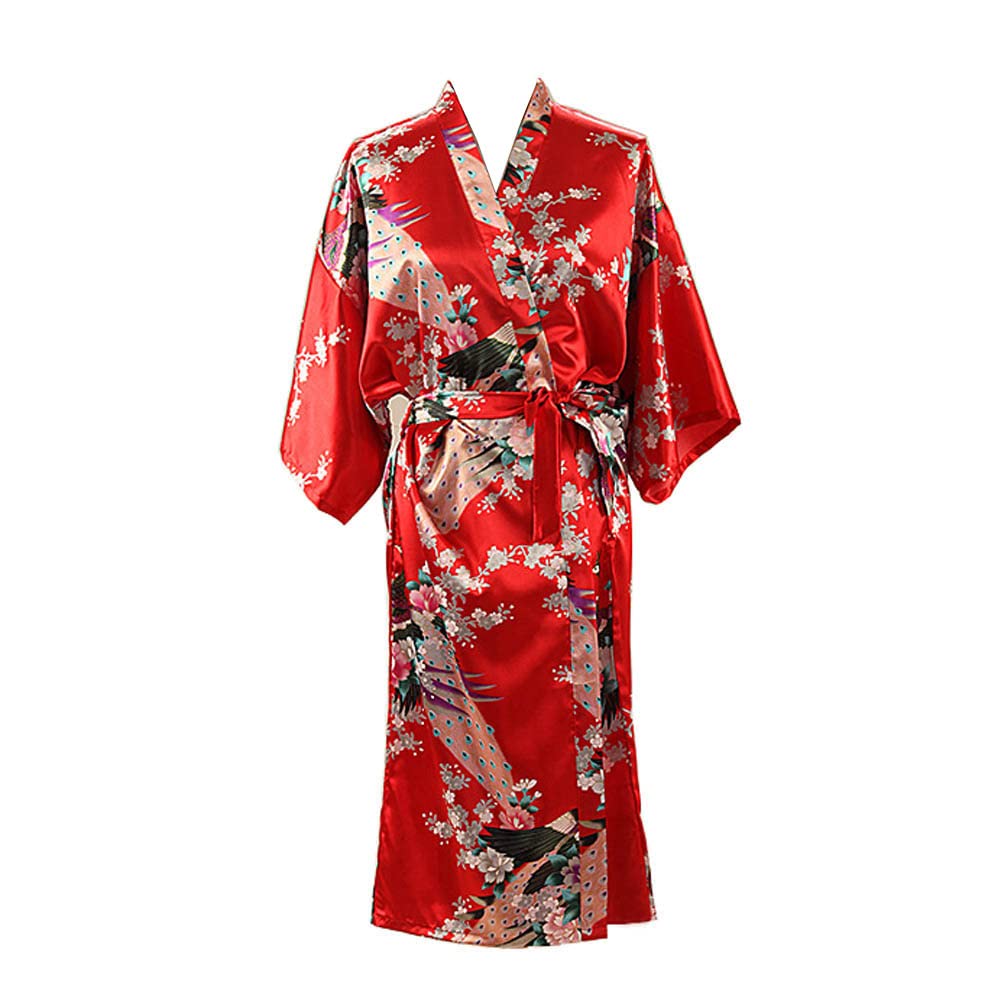 Kimono rouge en satin à motif de paon et de pivoines, posé sur un lit dans une chambre douce.