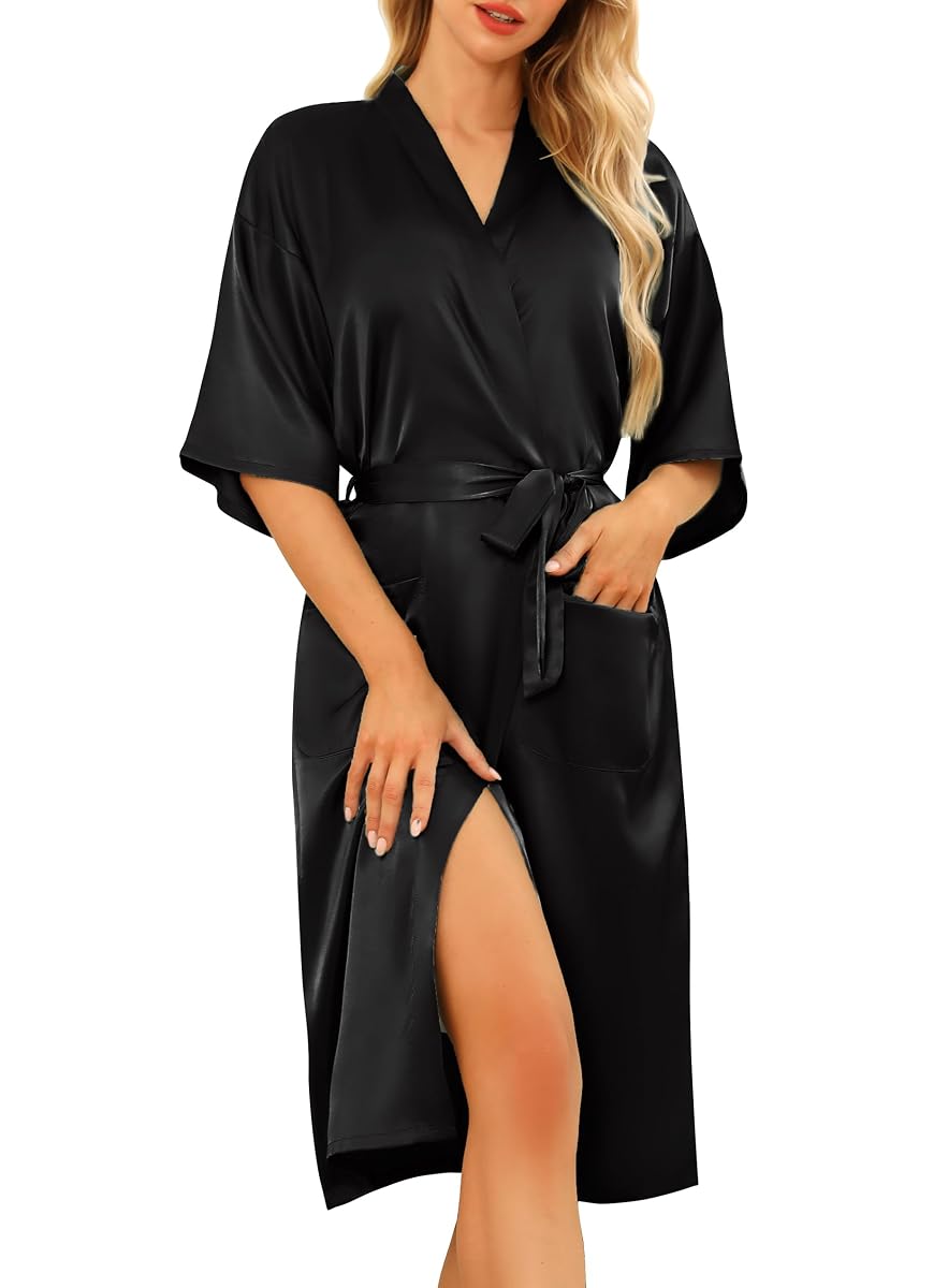 Kimono de chambre noir en satin, à col V, ceinture nouée et manches trois-quarts posé sur un lit.