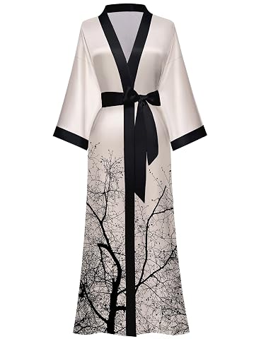 Kimono long en satin à motif floral sombre, suspendu dans une chambre lumineuse au linge froissé.
