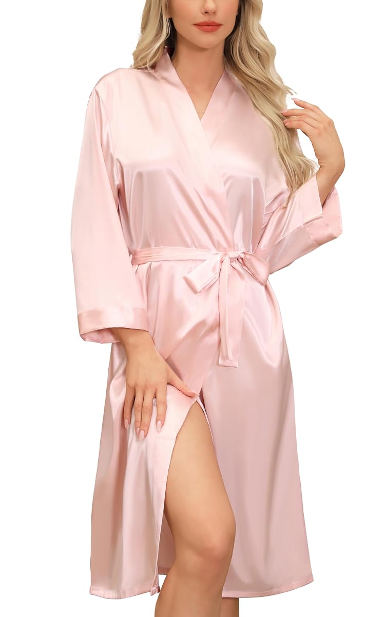 Peignoir kimono long rose en satin, col en V et ceinture nouée, suspendu dans une chambre calme.
