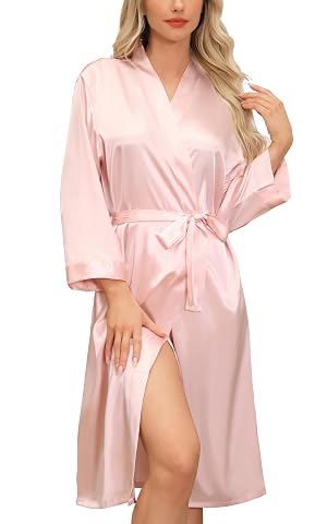 Peignoir kimono long rose en satin, col en V et ceinture nouée, suspendu dans une chambre calme.