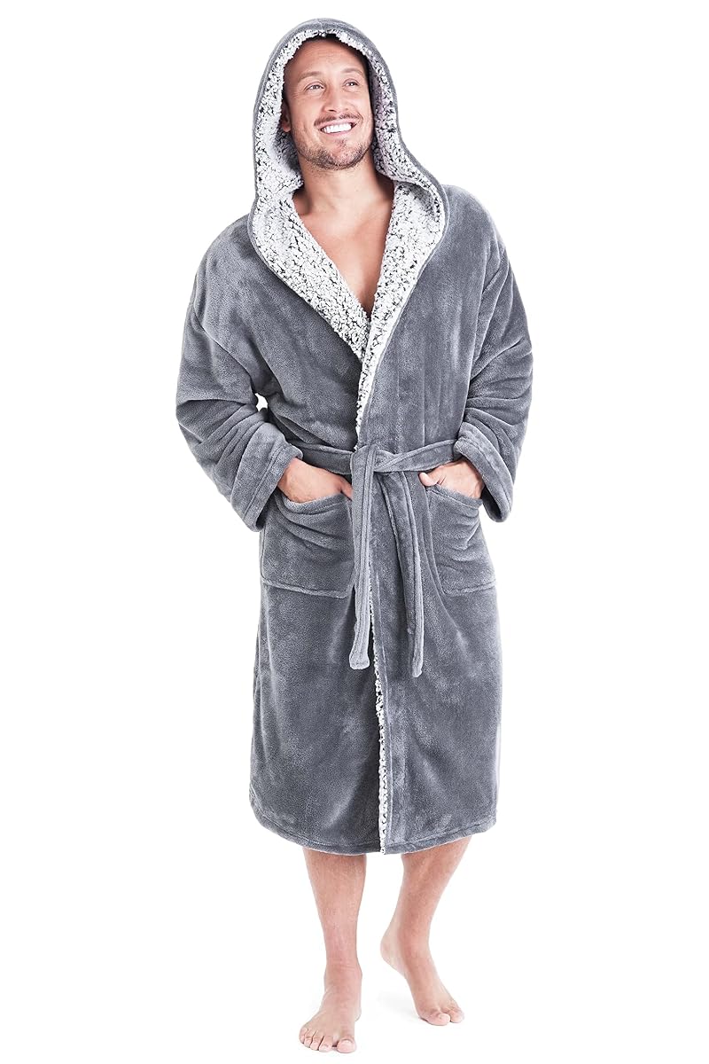Peignoir homme gris en polaire à capuche, ceinture nouée et deux grandes poches, posé sur un lit